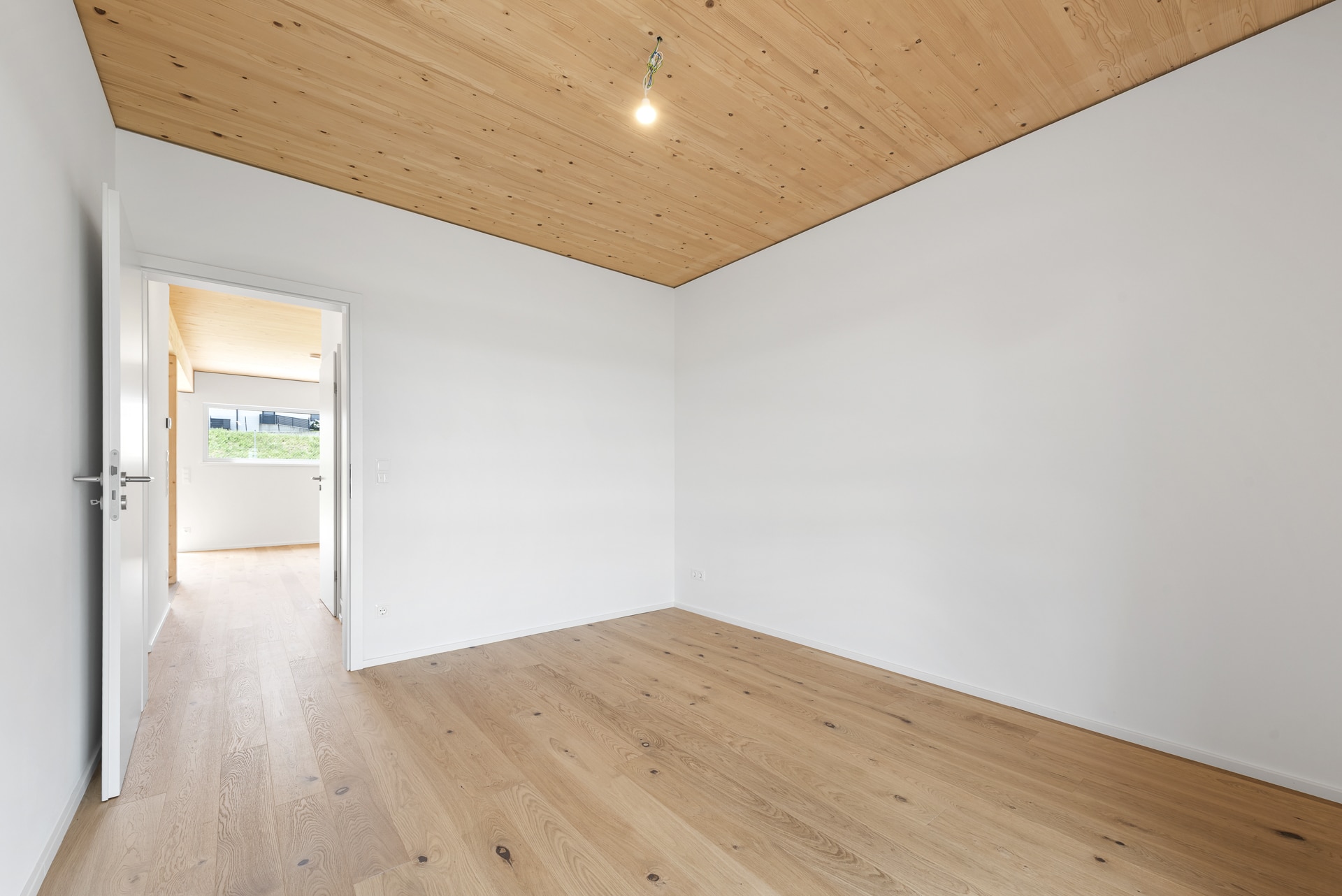 Zimmer mit Holzdecke und Parkettboden in einer Ökohome-Doppelhaushälfte in Rotenturm