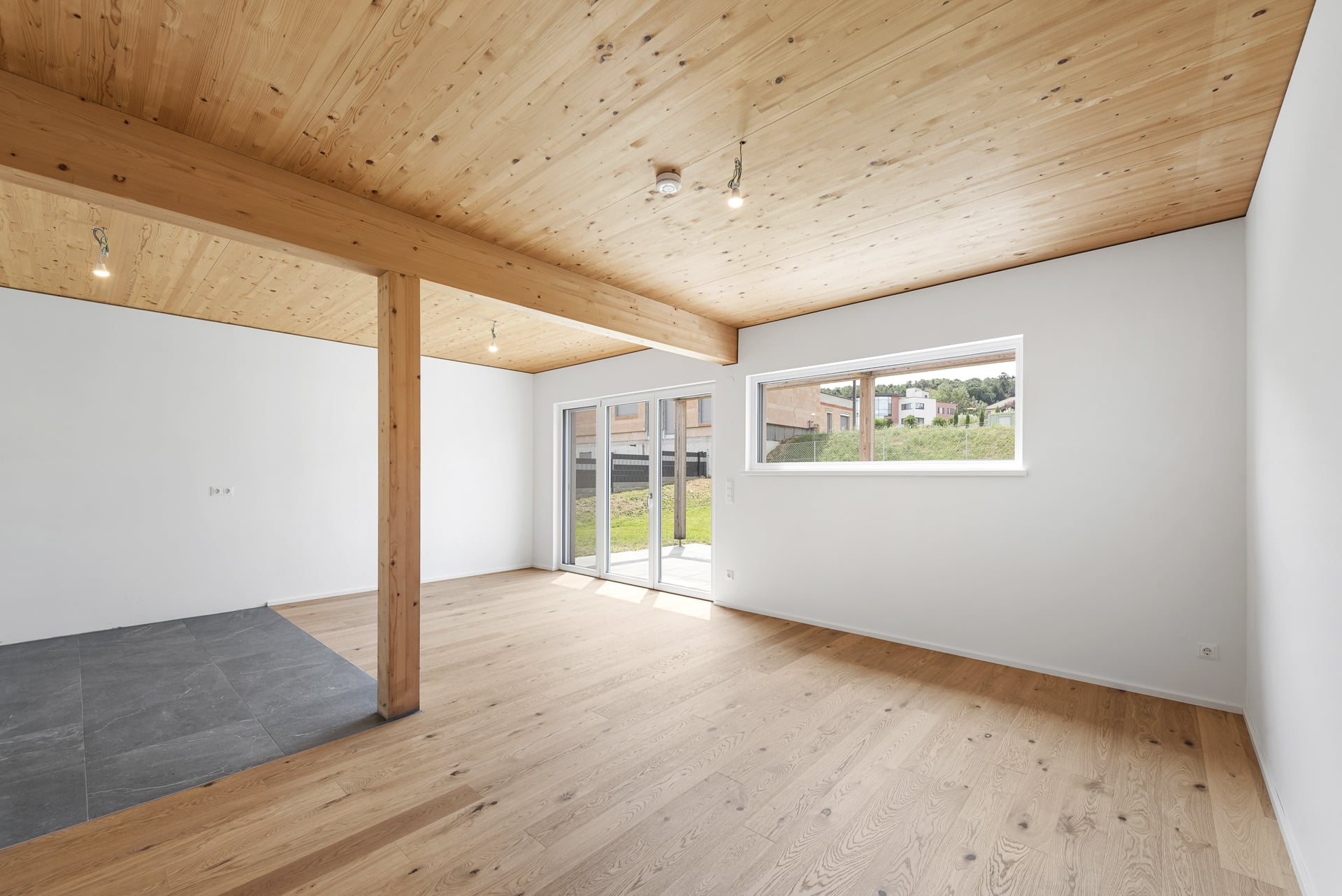 Heller Wohnraum mit Holzdecke und Terrassentür in einer Ökohome-Doppelhaushälfte in Rotenturm